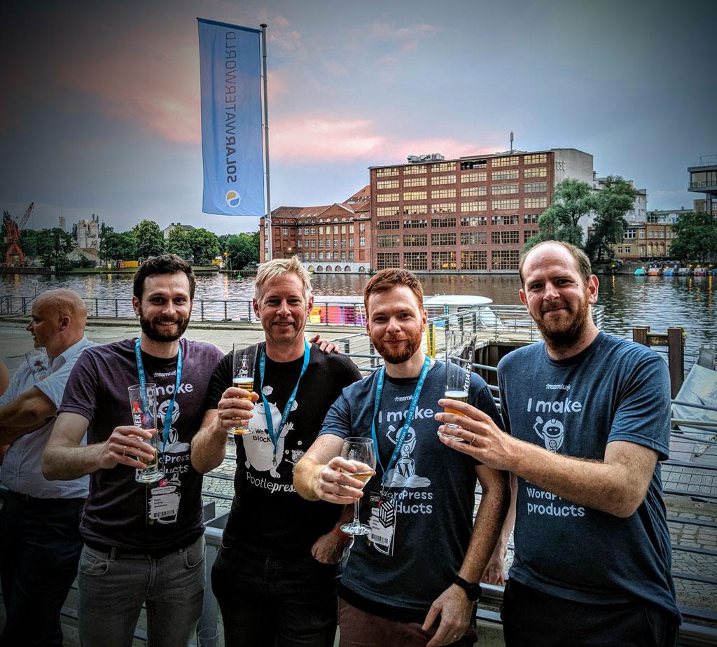 Freemius team holding a glass of beer in wordcamp 