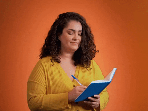 a girl in yellow shirt with blue notebook and pen