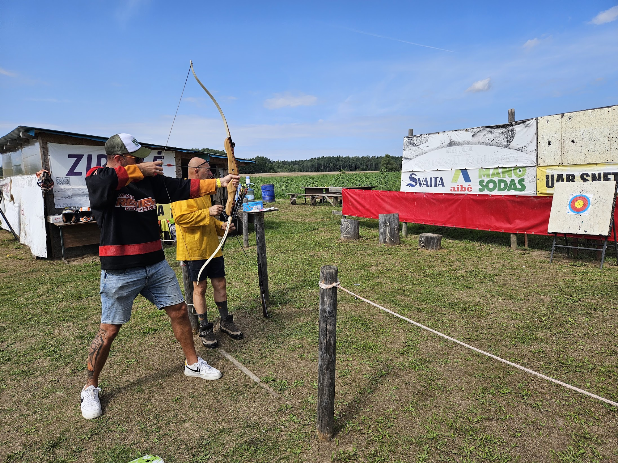 tauras sinkus shooting a target with a bow and arrow